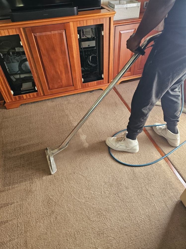 Technician steam cleaning boat cabin carpet with a wand