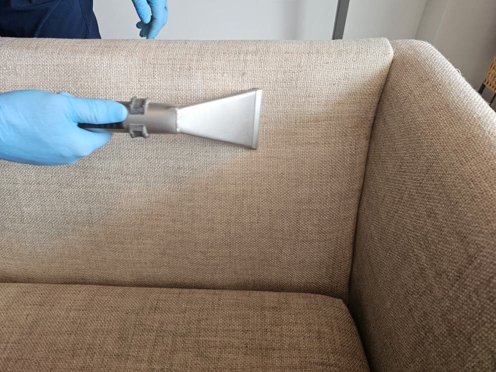 Extraction wand cleaning gray sofa fabric