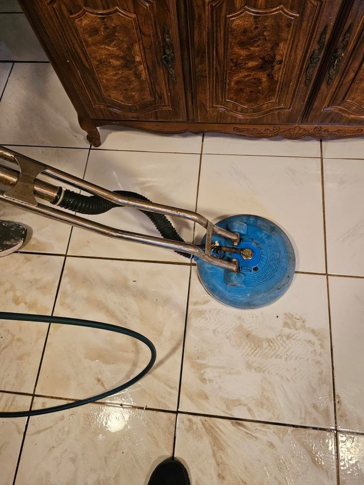Rotary extractor cleaning a cream tile floor