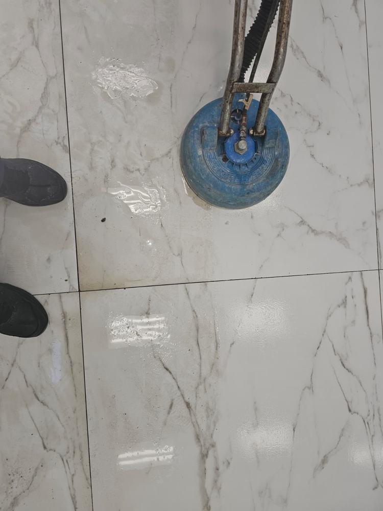 Rotary tool cleaning a white porcelain tile floor