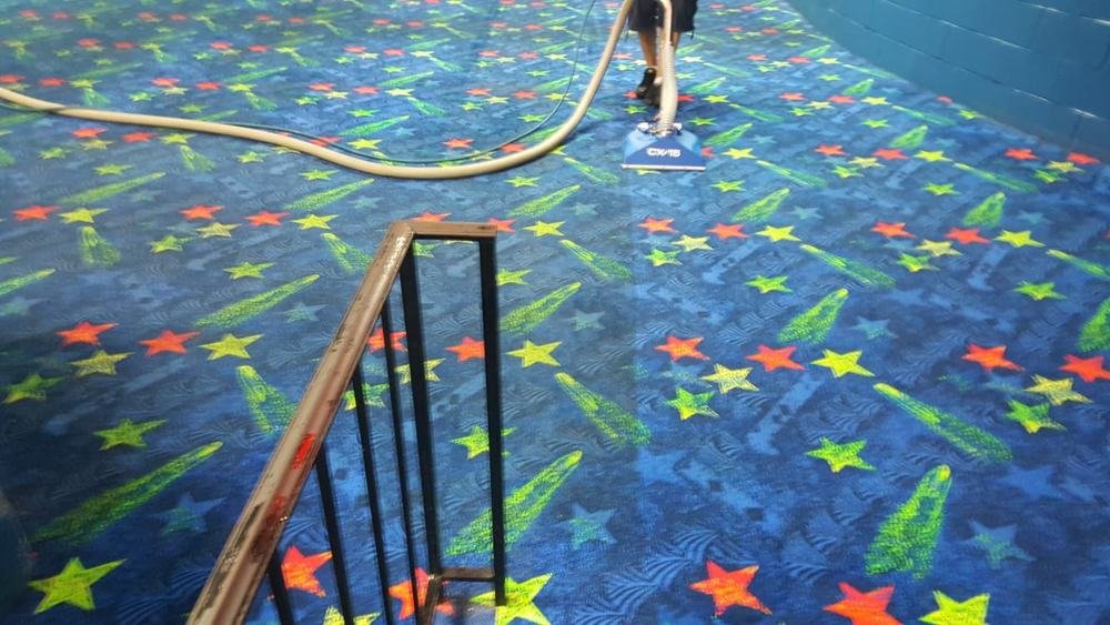 Commercial carpet being cleaned with a professional extraction wand