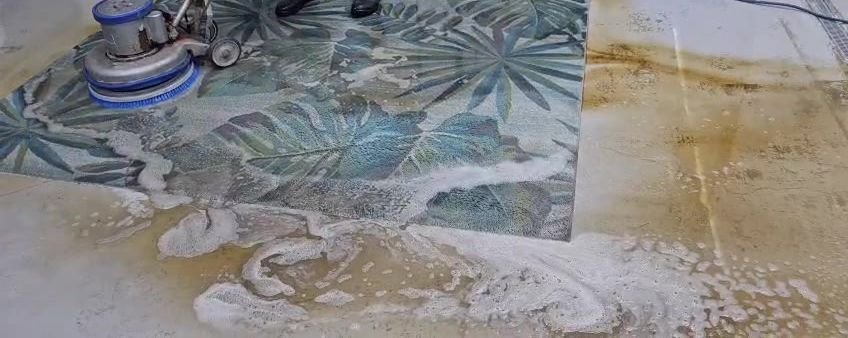 Rotary scrub machine cleaning a patterned area rug