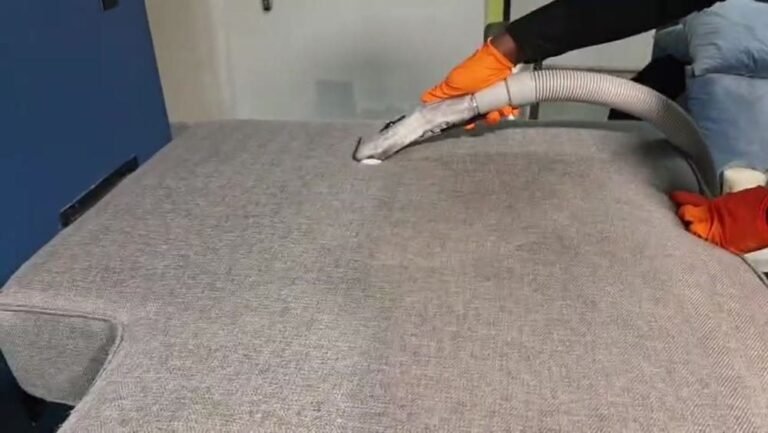 Technician cleaning upholstery with a hot water extraction wand